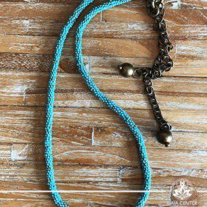 Summer necklace - blue or turquoise color beads on a long string with metal balls charms. Summer essential jewellery at Gaia Center in Cyprus. Shop online at https://gaia-center.com. Cyprus and Worldwide shipping.