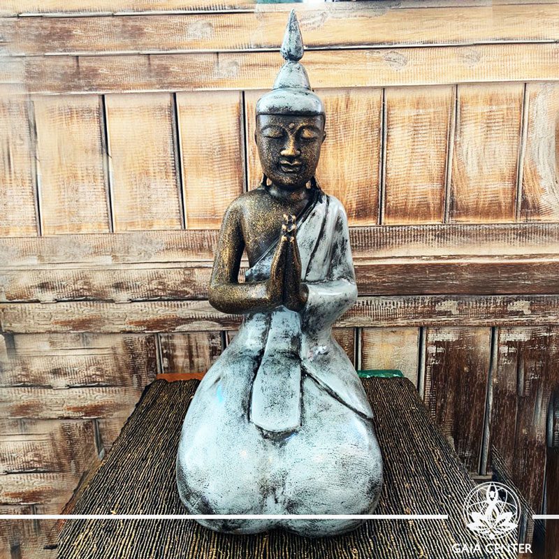 Buddha Statue grey and antique gold finishing sitting and meditating with hands gesturing NAMASTE at Gaia Center in Cyprus. Shop online at https://gaia-center.com. Cyprus and Worldwide shipping.