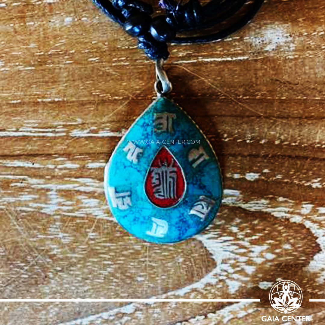 Tibetan Pendant drop shape inlaid with semiprecious gemstone: turquoise and red color. Made from metal with engraved buddhist symbol and kalachakra. Adjustable black string. Selection of Tibetan Jewelry made from crystals, gemstones, combination of metals at Gaia Center | Cyprus.