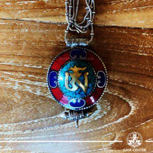 Tibetan gau pendant selection with semiprecious stones. Tibetan Pendant Om symbol inlaid with turquoise, coral and lapis lazuli . Made from combination of metals, Blue, Red and Silver color design. Long chain. Selection of Tibetan Jewelry made from crystals, gemstones at Gaia Center | Cyprus.
