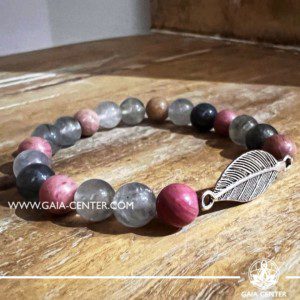 Crystal Bracelet Rhodonite and Grey Quartz with metal Feather charm and elastic string - made with 8mm gemstone beads. Crystal and Gemstone Jewellery Selection at Gaia Center in Cyprus. Order online, Cyprus islandwide delivery: Limassol, Larnaca, Paphos, Nicosia. Europe and Worldwide shipping.